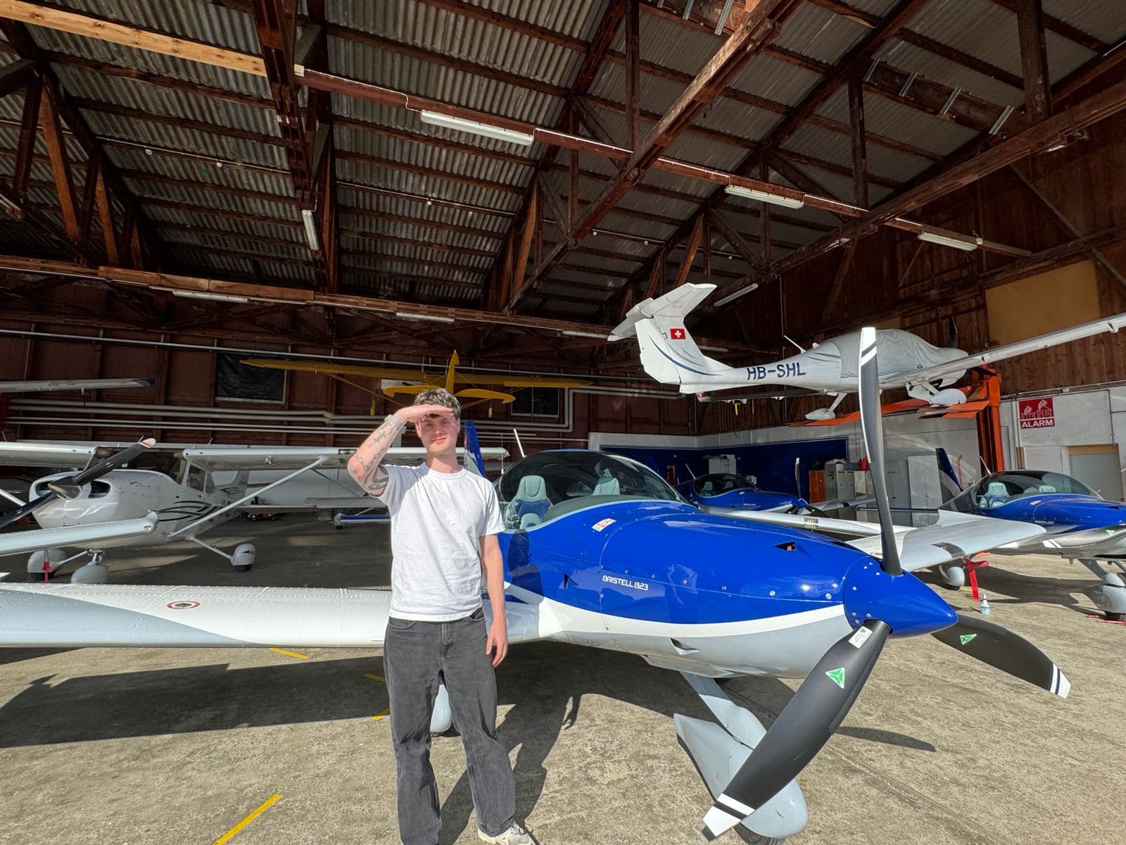 Noa in a hangar in front of a plane
